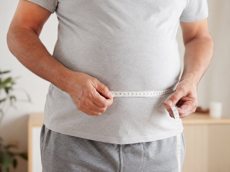 Mulher medindo circunferência abdominal — gordura visceral na síndrome metabólica